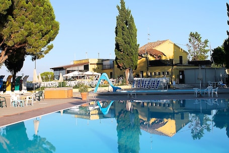 Una piscina al aire libre de temporada, sombrillas