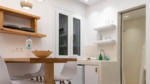 Una cocina moderna con armarios blancos, una mesa de comedor de madera y un horno empotrado.