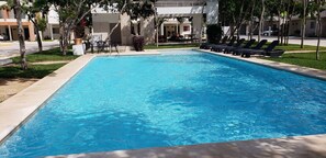 Una piscina al aire libre, sombrillas