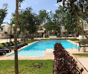 Una piscina al aire libre, sombrillas