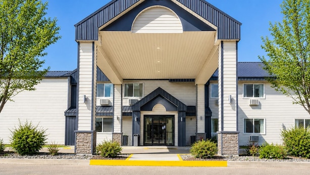 A modern building with a covered entrance, large windows, and a stone base. - Morton Inn (Morton)