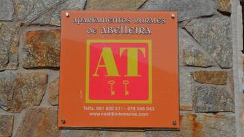 Schild mit der Aufschrift 'apartamentos rurales de abelleira', Kontaktinformationen und einer Website-URL.