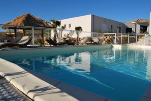 Piscine extérieure en saison, chaises longues