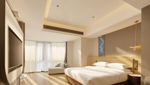 A hotel room with a large bed, a flat-screen TV, a sofa, and a window with curtains. - Jin Li Hua Grand Hotel (Shaodong)