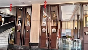A modern interior with a curved staircase, wooden panel dividers, and hanging red lanterns. - Jin Li Hua Grand Hotel (Shaodong)