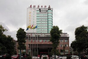 A hotel with a prominent sign reading "MUA GRAND HOTEL" and multiple flags in front. - Jin Li Hua Grand Hotel (Shaodong)