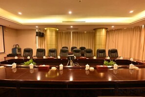 A conference room with a long table, multiple chairs, and a large screen. - Jin Li Hua Grand Hotel (Shaodong)