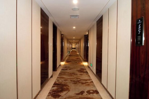 A long, narrow hallway with a patterned carpet, wooden doors, and a sign indicating room number 1907. - Jin Li Hua Grand Hotel (Shaodong)