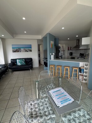 Un espace de vie moderne comprenant un coin repas, une cuisine et un tableau accroché au mur.