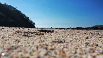 En la playa, playa de arena blanca, camastros y toallas de playa