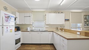 A modern kitchen with white cabinets, a wooden countertop, and a built-in oven.
