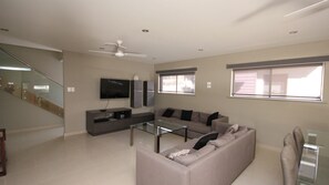 Relax in this stylish living room with a sofa, flat-screen TV, and glass coffee table.