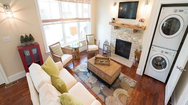 A living room with a fireplace, a television, and a washing machine.