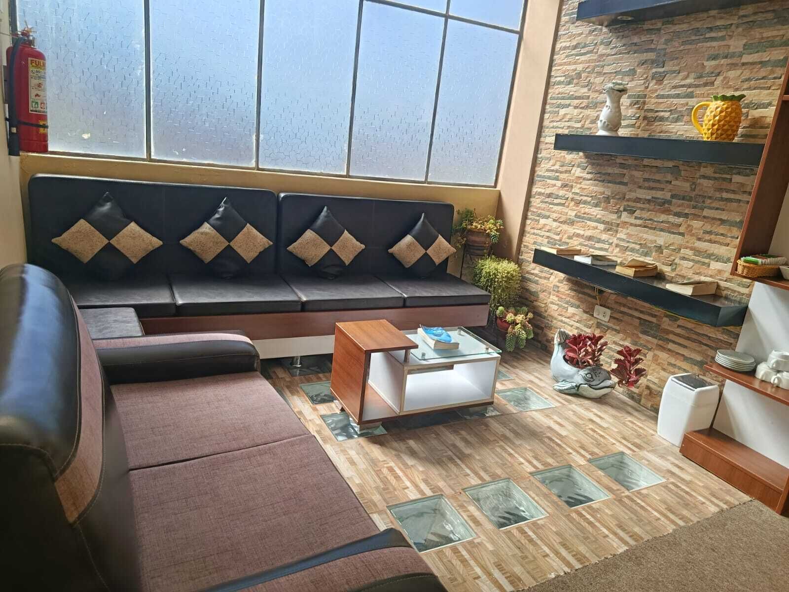 Una sala de estar moderna con un sofá seccional, una mesa de centro de vidrio y una chimenea.