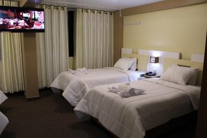A hotel room with two beds, a television, and a nightstand with a phone. - Kaaro Hotel Puno (Puno)