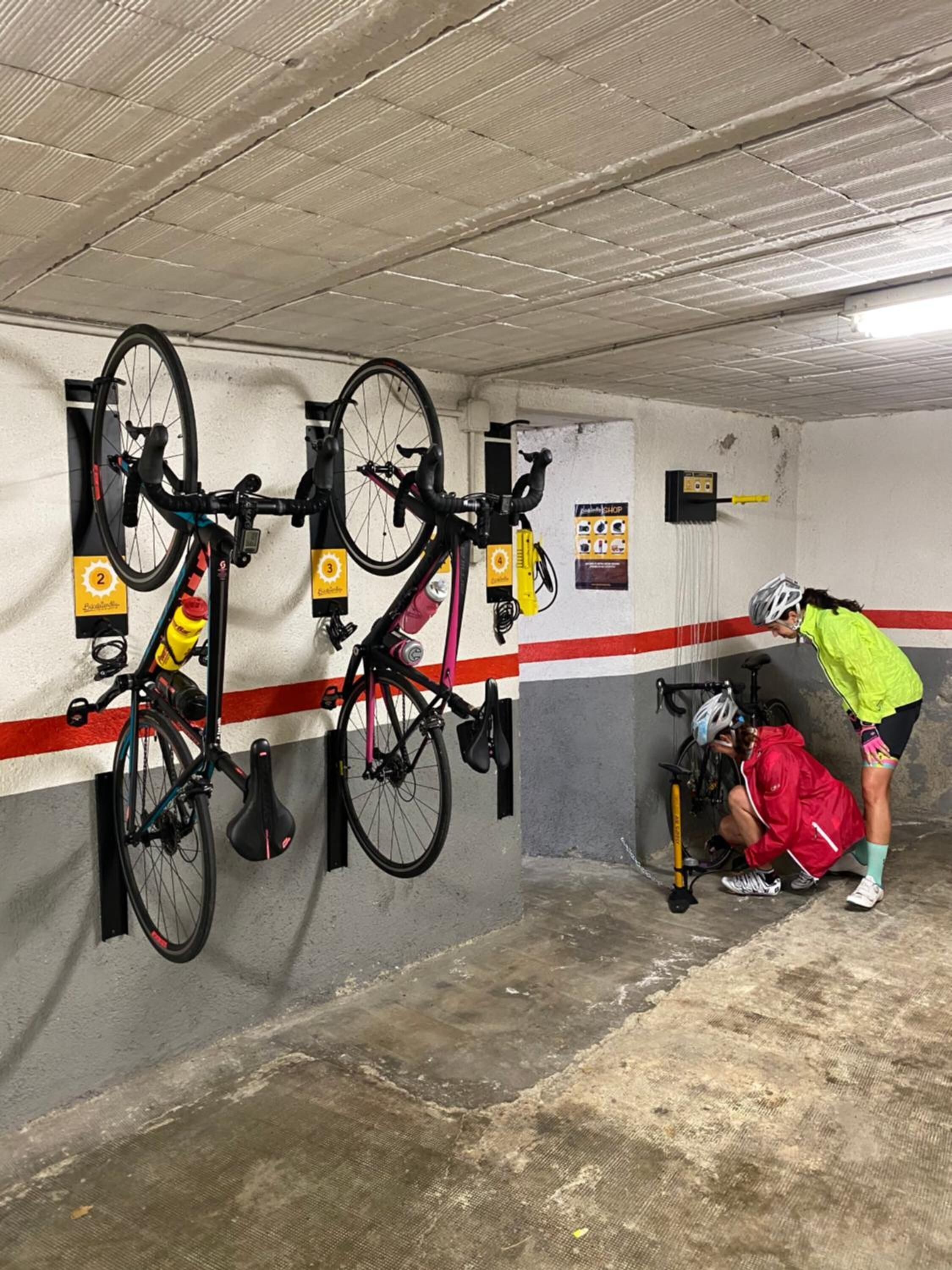 A bicycle parking area with multiple bike racks and a person crouching near a bike.