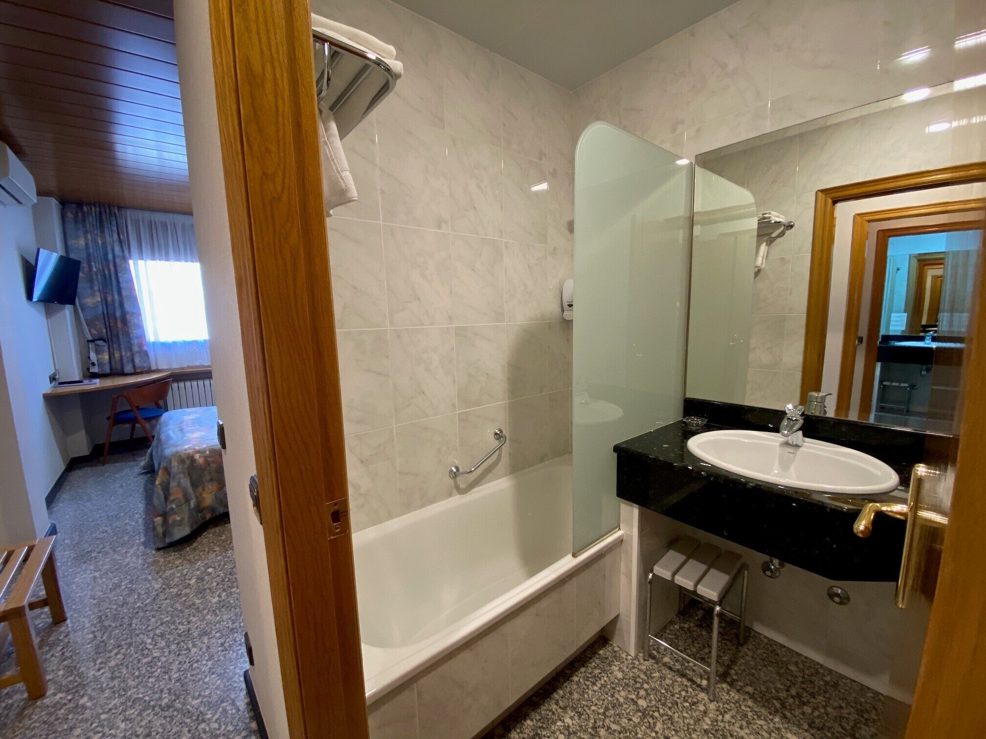 Un baño de hotel con bañera, lavabo y ducha.