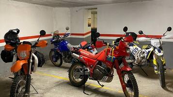 Un aparcamiento con motocicletas estacionadas en filas.