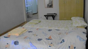 Een slaapkamer met een bed, een kledingkast en een bureau.