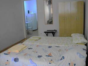 Een slaapkamer met een bed, een kledingkast en een bureau.