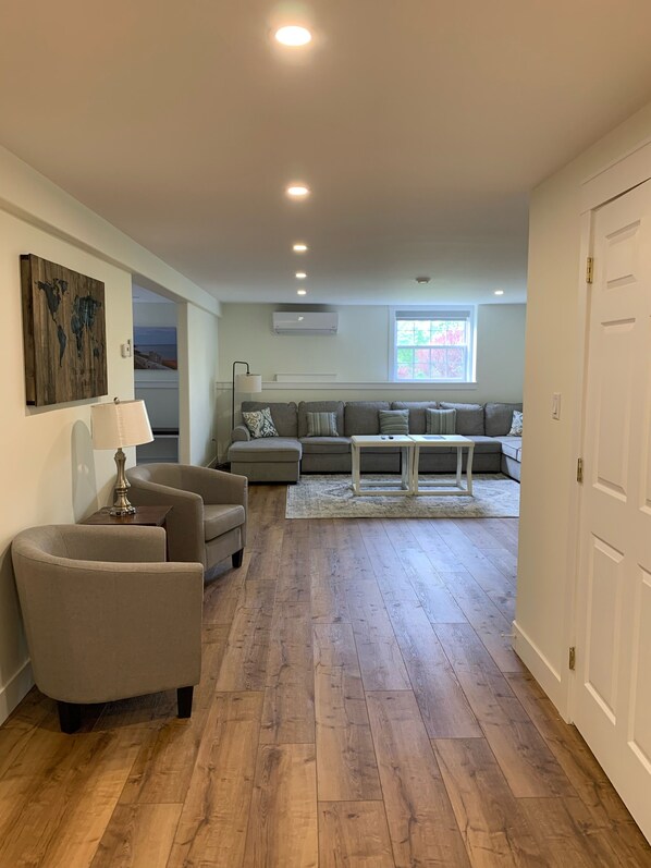 A spacious living room with a wooden floor, a grey sofa set, a coffee table, and a lamp. - Large 3 Bedroom Home + NEW 2021 2 Bedrooms aprtmt for add’l fee$ per night (Long Creek)