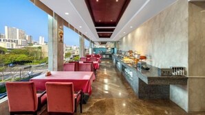 A modern restaurant with red tables and chairs, a marble floor, and a city view. - Heping Hotel (Tongxiang)