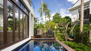 A swimming pool with a glass enclosure, surrounded by lush greenery and palm trees. - Gardenia Pool Villa - 2 Bedroom (Ko Samui)