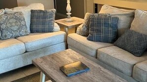 En stue med to sofaer, et sofabord, en lampe og et maleri på væggen.