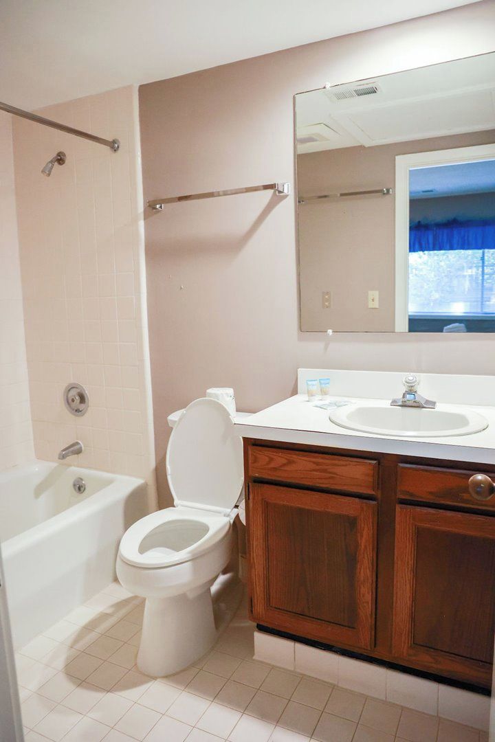 A bathroom with a toilet, sink, and bathtub.