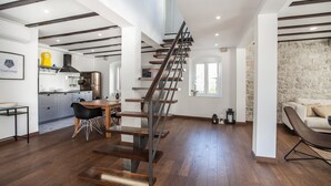 Un interior moderno con una escalera de madera, una cocina y un comedor.