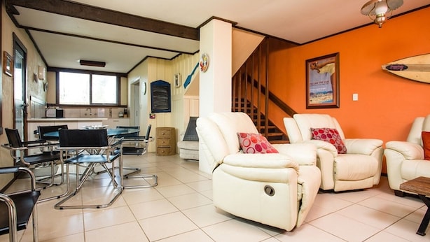 A living room with a dining area, a kitchen, and a staircase. - Banksia Seven - Merimbula (Merimbula)