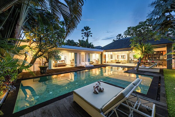 Alberca al aire libre y camastros 