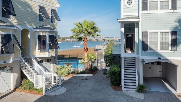 Un immeuble résidentiel doté d’une piscine, d’un escalier et offrant une vue sur l’eau.