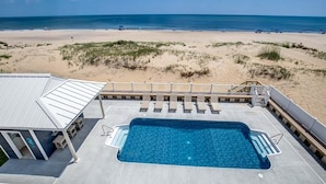 Una piscina en la azotea con vista a la playa y al océano.