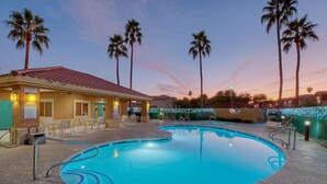 A pool area with a lounge, palm trees, and a building with a 'Smoke Free' sign. - SL Lakes Condo w/GOLF VIEWS, Gated Comm w/Htd POOL &Spa, Walk to Mall w/Eats & Theater (Mesa)