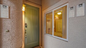 A textured wall, a green door with a vertical handle, and a window with a white frame. - SL Lakes Condo w/GOLF VIEWS, Gated Comm w/Htd POOL &Spa, Walk to Mall w/Eats & Theater (Mesa)