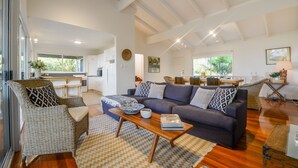 A spacious living area with a sofa, chairs, and a dining table.