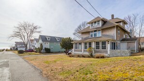 A two-story house with a stone foundation, a garage, and a covered porch. - Laurel Beach-Milford (Milford)
