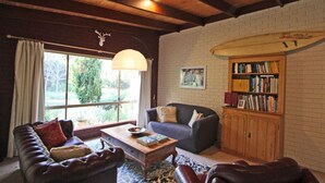 Una sala de estar acogedora con un sofá de cuero, una mesa de centro de madera y una estantería.