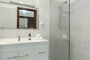 Kombination af bruser/badekar, hårtørrer, håndklæder