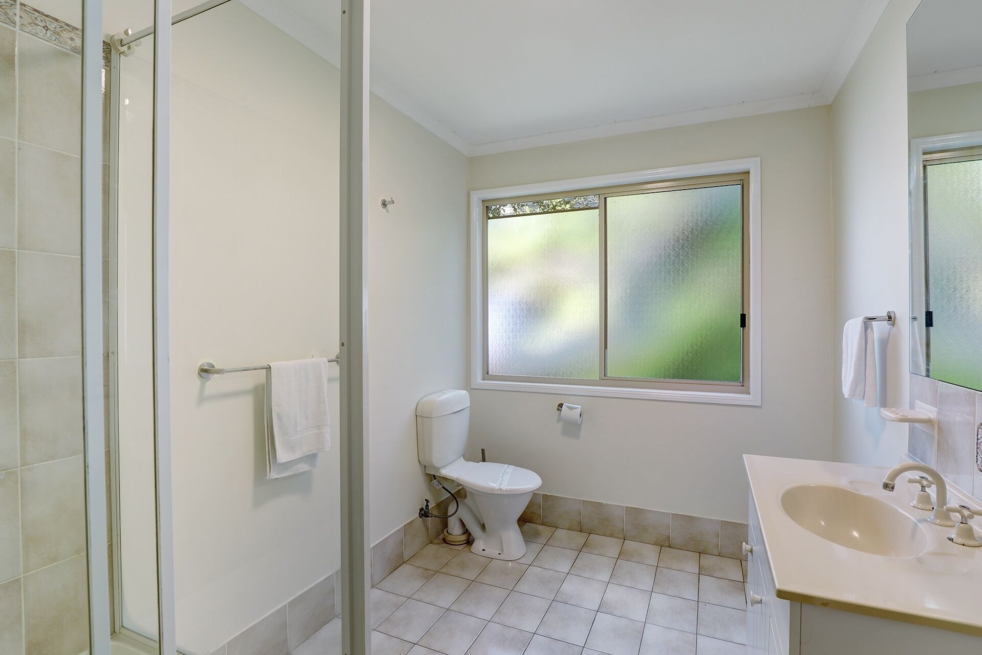Une salle de bain comprenant des toilettes, un lavabo et un espace douche.