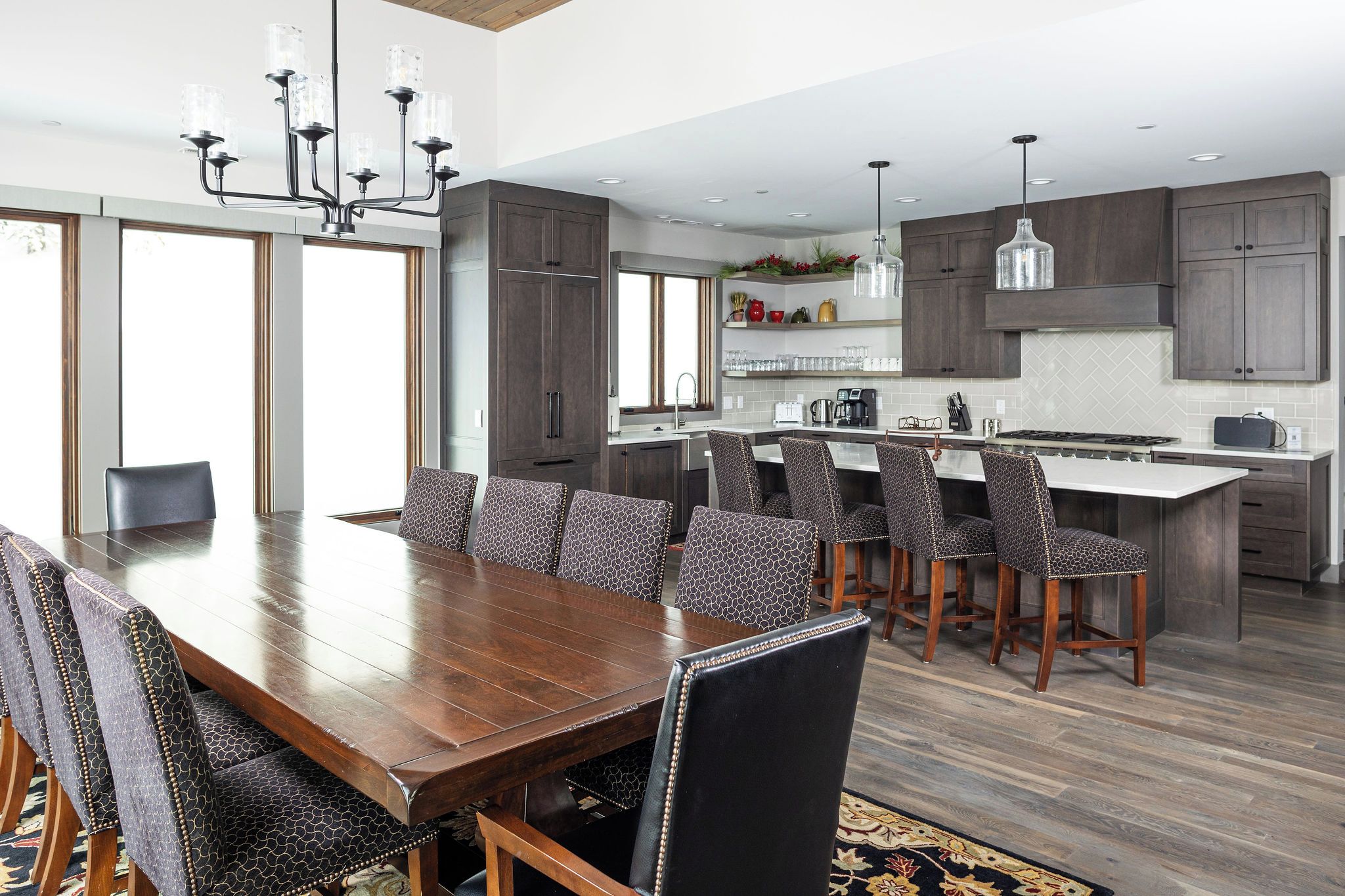 A modern kitchen with dark wood cabinets, a central island, and pendant lighting.