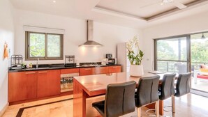 A modern kitchen with a dining area, large windows, and a ceiling fan. - 2 Bedroom Pool Villa Nature SDV004 By Samui Dream Villas (Mae Nam)