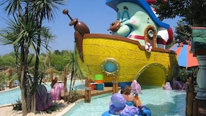 Un parc aquatique doté d’un vaste espace de jeux sur le thème des navires, comprenant une piscine en forme de bateau et diverses attractions aquatiques.
