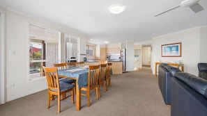 A modern apartment with a dining area, kitchen, and living room.