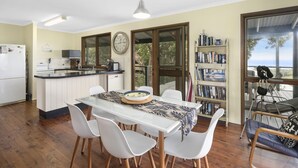 A modern kitchen with a dining area, a bookshelf, and a view of the outdoors. - Pet friendly property with water views (Point Lookout)