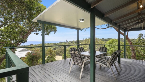 A covered outdoor area with a table and chairs, overlooking a scenic view. - Pet friendly property with water views (Point Lookout)