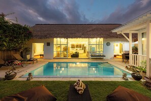 Una piscina al aire libre, tumbonas