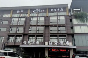 A multi-story building with a sign indicating it is a hotel. - yiduo hotel (Hangzhou)