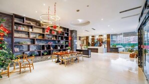 A modern hotel lobby with a dining area, a reception desk, and a large window offering a city view. - yiduo hotel (Hangzhou)